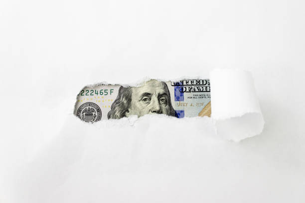 istock Benjamin Franklin portrait on 100 banknote in torn paper hole. Benjamin Franklin's eyes from a hundred-dollar bill. 1372810220