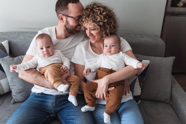 istock Happy couple holding newborn twin babies 1372814372