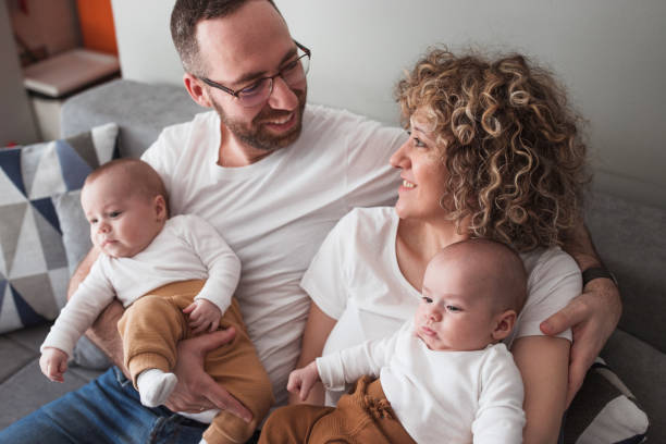istock Couple holding identical twin babies and looking at each other 1372814920
