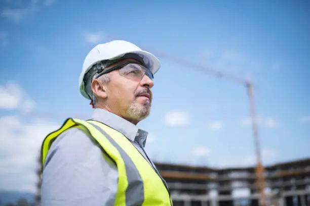 Portrait of confident and successful senior architect at construction site.