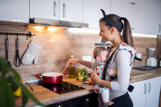 istock Multi-task mother cooking and taking care of newborn son. 1372814965
