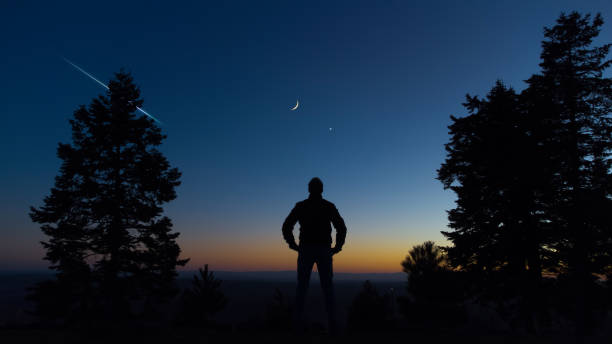 istock Man observing evening sky with stars, planets and crescent Moon. 1372815565
