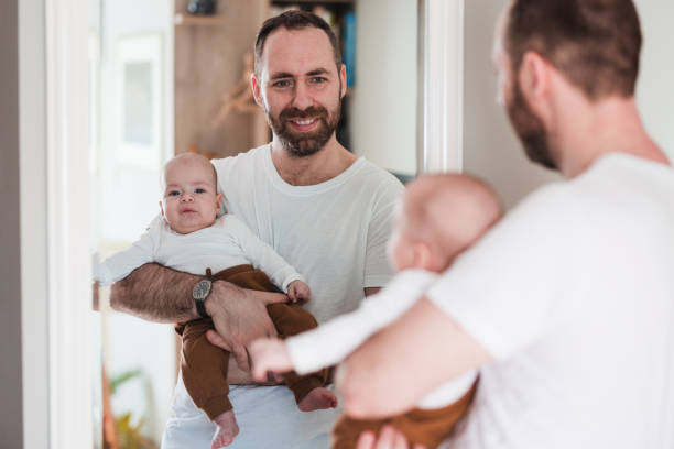 istock Happy father with a baby boy in his hands looking at the mirror reflection 1372815645