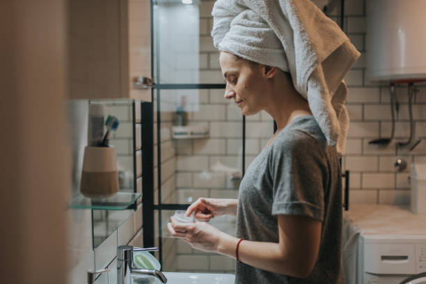 istock Pretty young woman using cream for moisturizing her skin 1372817207