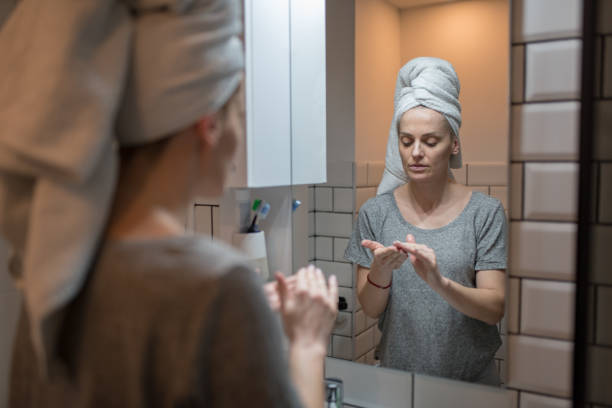 istock Young woman applying moisturizer on face after the shower 1372817259