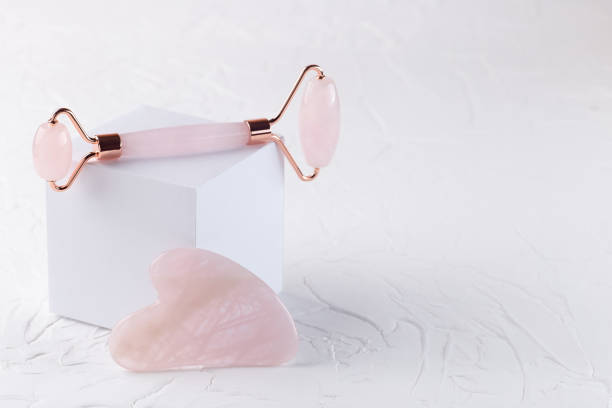 istock Rose quartz crystal facial roller and massage tool Gua sha on a white background, horizontal 1372818269