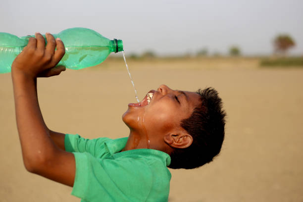 spragniony biedny chłopiec pijący wodę - scarcity water people land zdjęcia i obrazy z banku zdjęć