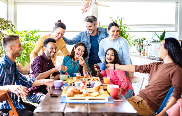 junge leute trinken und essen in der kaffeebar - freunde reden und haben gemeinsam spaß in der schicken cafeteria - freundschafts-lifestyle-konzept mit glücklichen jungs und mädchen im restaurant-café - heller filter - breakfast eating people teens stock-fotos und bilder