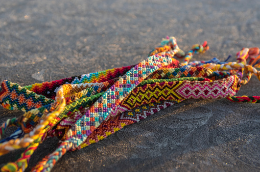 Handmade homemade colorful natural woven bracelets of friendship on gray frozen background, bright colors
