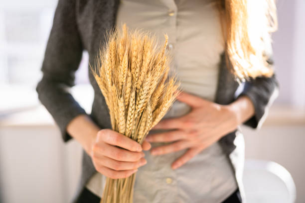 Celiac Disease And Gluten Intolerance. Women Holding Spikelet Celiac Disease And Gluten Intolerance. Women Holding Spikelet Of Wheat food allergies stock pictures, royalty-free photos & images