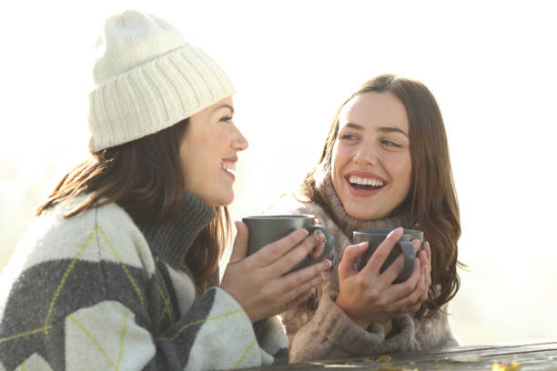 istock Happy friends drinking and talking in a park in winter 1372831843