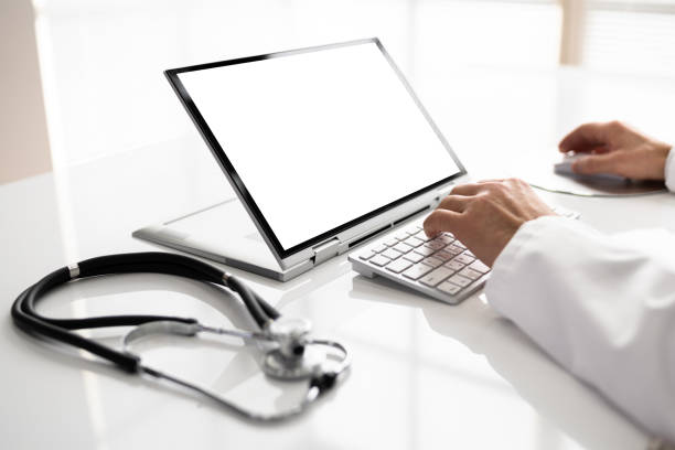 Midsection Of Male Doctor Using Laptop At Desk In Clinic