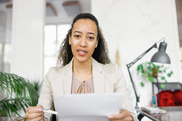 istock Businesswoman holding a document video conferencing in office 1372834205