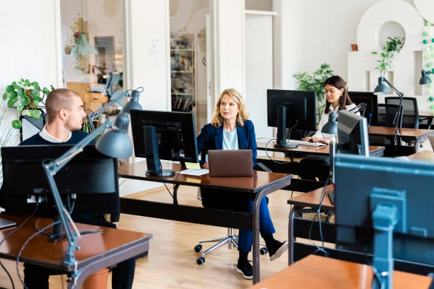 istock Business professionals working at their desks in open plan office 1372834497