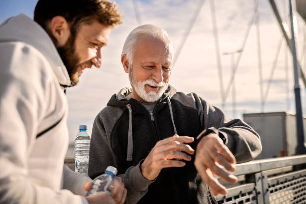 성숙한 젊은 남자 조깅 에 a 다리 복용 a 휴식 보고 스마트 시계 - senior adult outdoors wellbeing sky 뉴스 사진 이미지