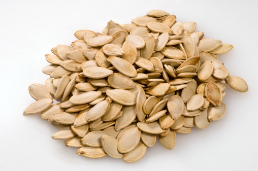 Pile of toasted Pumpkin seeds on white background