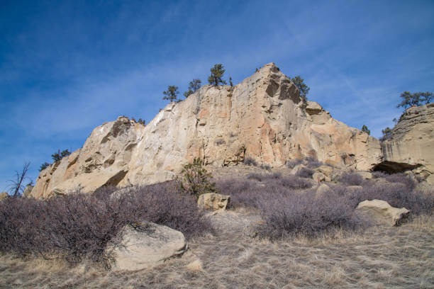 Rock climbers rest on a distant rock wall in Diablo Canyon, between Los Alamos and Santa Fe New Mexico, with the Sangre de Cristo Mountains in the background.