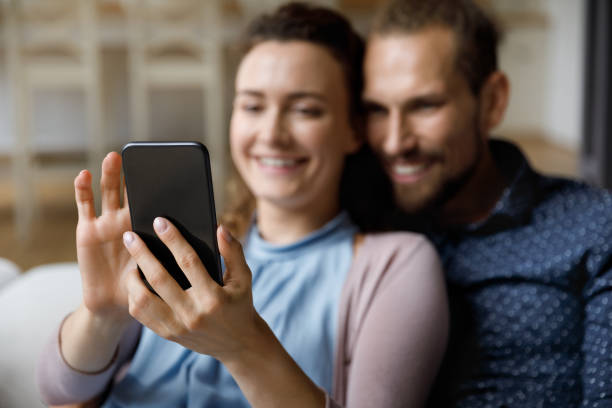 istock Close up happy young couple using cellphone. 1372859416