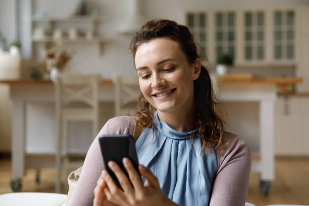 istock Happy young woman using smartphone at home. 1372859420