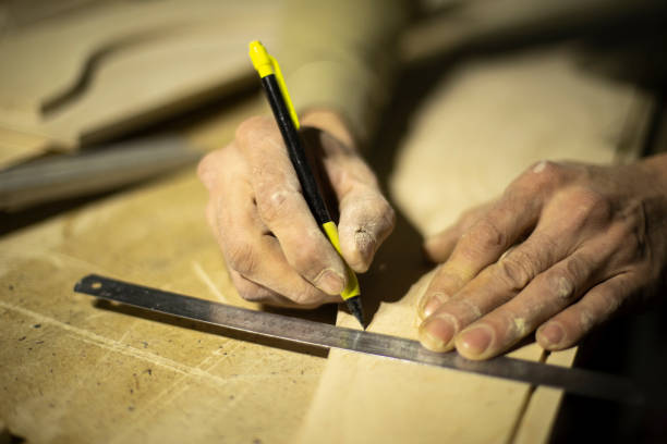 istock Marking on ruler with pencil. Drawing line on tree. Hands of carpenter. 1372860591