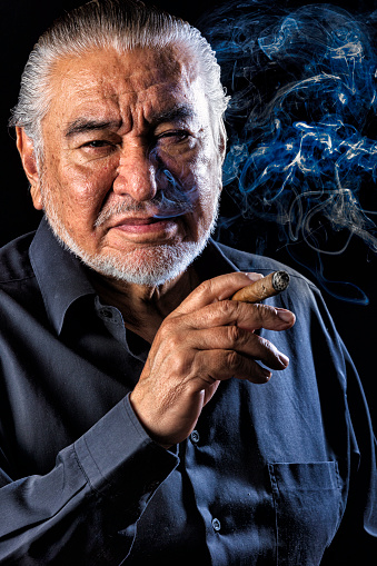 Burning cigar against black background close up photo