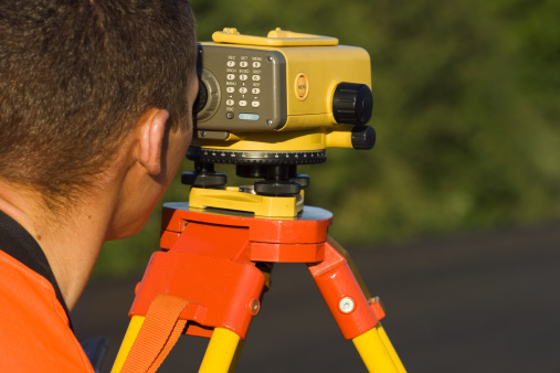 Land surveyor looking through digital level lunette.