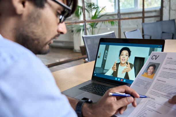 Indian human resource manager holding cv having virtual job interview. Indian human resource manager holding cv having virtual job interview conversation with remote female candidate during distant business video call on laptop computer. Online recruitment concept. recruiter stock pictures, royalty-free photos & images