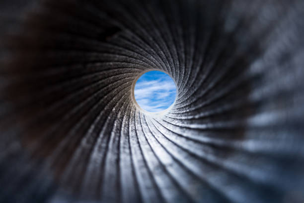 View through cannon barrel on blue sky with clouds A view through a dark barrel of cannon to the blue sky with white fluffy clouds. Close up, selective focus. Abstract background concept focus concept stock pictures, royalty-free photos & images