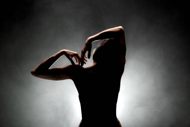 istock silhouette modern ballet dancer posing on dark background with smoke 1372874767