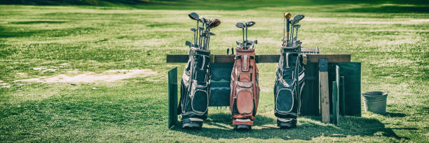 baner z torbami golfowymi z kijami na polu golfowym zielona trawa - golf bag zdjęcia i obrazy z banku zdjęć