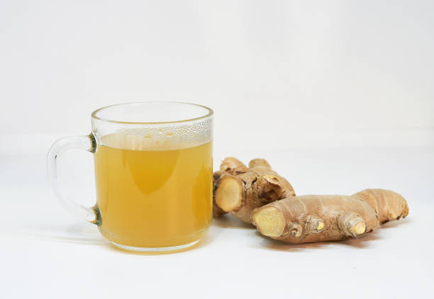 istock Glass of ginger tea  lemon with ginger root  on white background. 1372886917