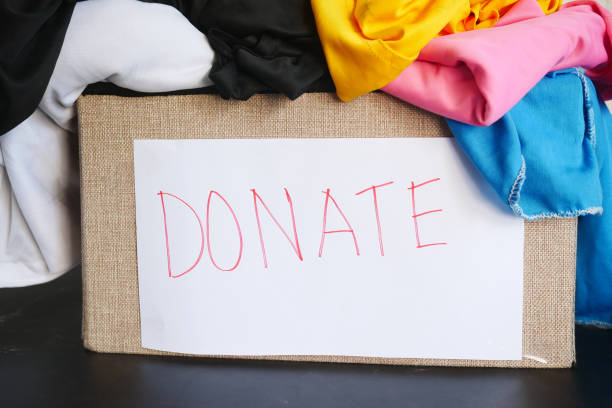 istock Donation box with donation clothes on a wooden table . 1372889436