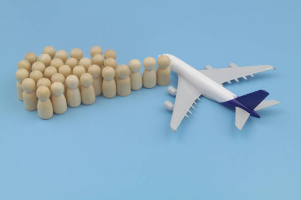 istock Airplane model and wooden people figures on blue background. 1372890385