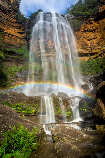 Wentworth Falls cascades over the cliff ledge to the middle tier, water flowing veiled like a bride and with a beautiful  rainbow stretching across