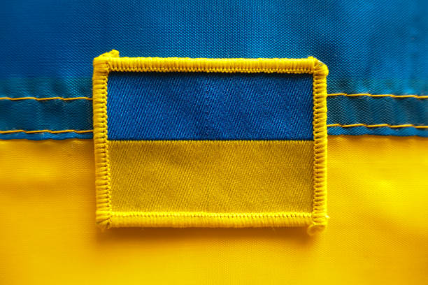 Ukrainian Flags The Ukrainian flag patch worn by all members of the Ukrainian armed forces, seen on the soldiers defending Ukraine against Russian military forces.  The patch in viewed on top of a flag of Ukraine. golden ring of russia photos stock pictures, royalty-free photos & images