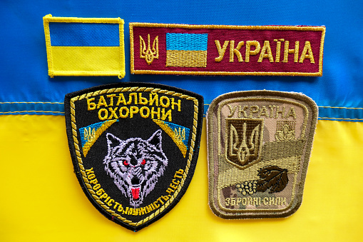 Ukrainian military badges on top of a Ukrainian flag.