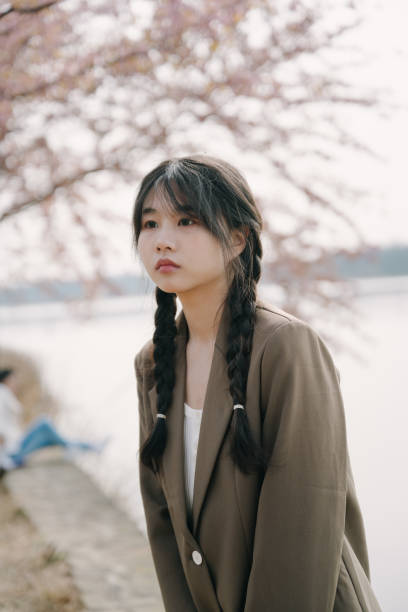 istock Beautiful asian girls under cherry trees 1372898845