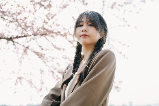 istock Beautiful asian girls under cherry trees 1372898861
