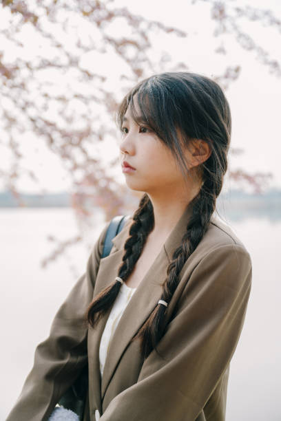 istock Beautiful asian girls under cherry trees 1372898883