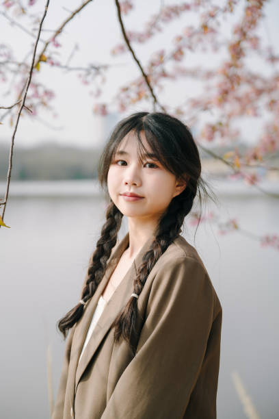 istock Beautiful asian girls under cherry trees 1372898904