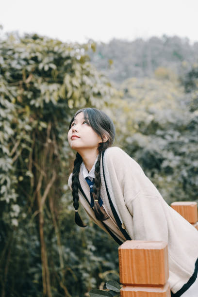 istock A beautiful asian girl leaning on a railing on a sunny day 1372899614