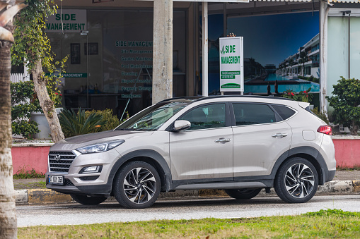Side, Turkey – February 01 2022: beige Hyundai Tucson  is parked  on the street on a warm day against the backdrop of a shop