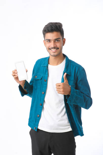 istock Young indian man showing smartphone screen on white background. 1372902161