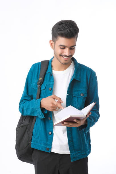 Young Indian college student holding dairy in hand on white background. stock photo