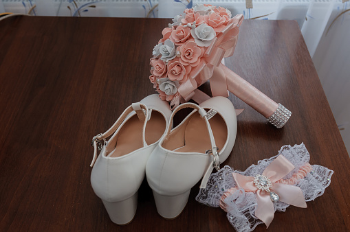 Bride's accessories. Women's shoes, garter, bridal bouquet, candles pendant