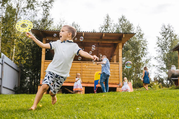 Little boy run with blowing soap bubbles