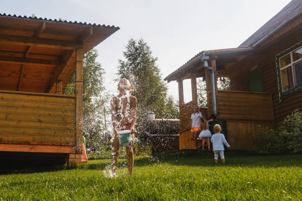 istock Happy kids playing with water in garden 1372904048