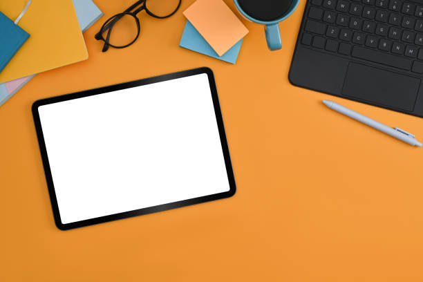 istock Digital tablet with white screen, stylus pen, sticky notes and coffee cup on yellow background. 1372905367