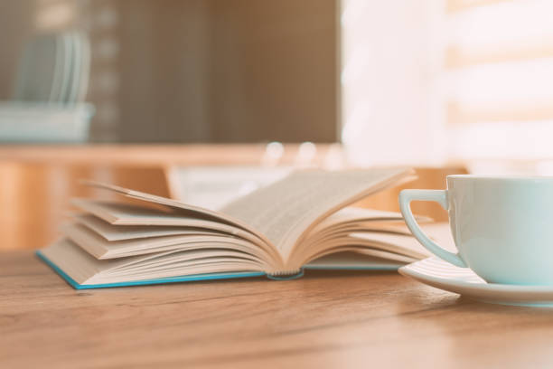 istock Open book and coffee cup on the table, reading at home in the morning 1372911109