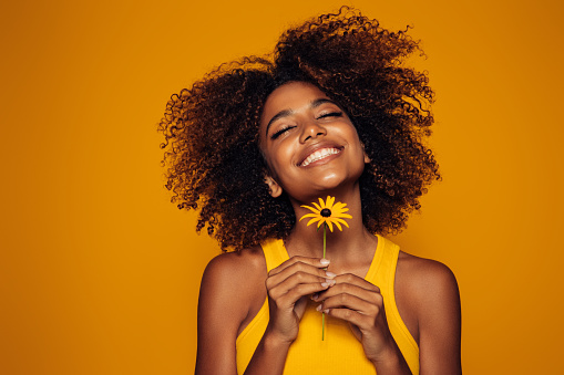 Beautiful afro woman with bunch of flowers